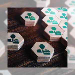 Pequeñas fichas de madera formando un rompecabezas, cada una con una imagen de una persona de negocios, simbolizando la importancia de los patrocinadores para unir esfuerzos.